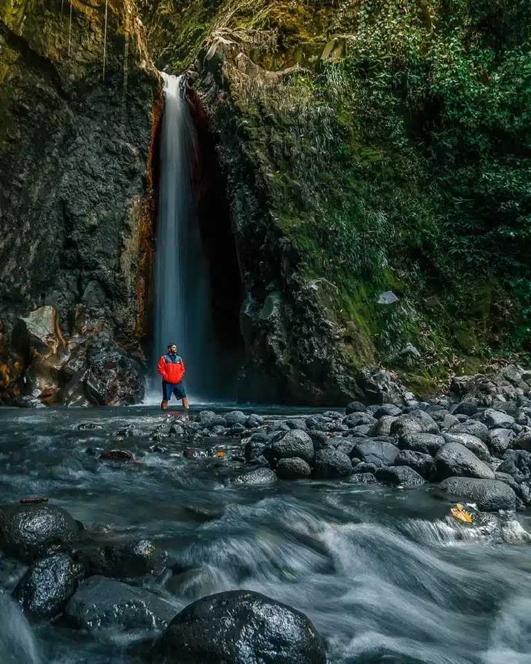 Guest at the foot of a waterfall in the Sensoria rainforest reserve